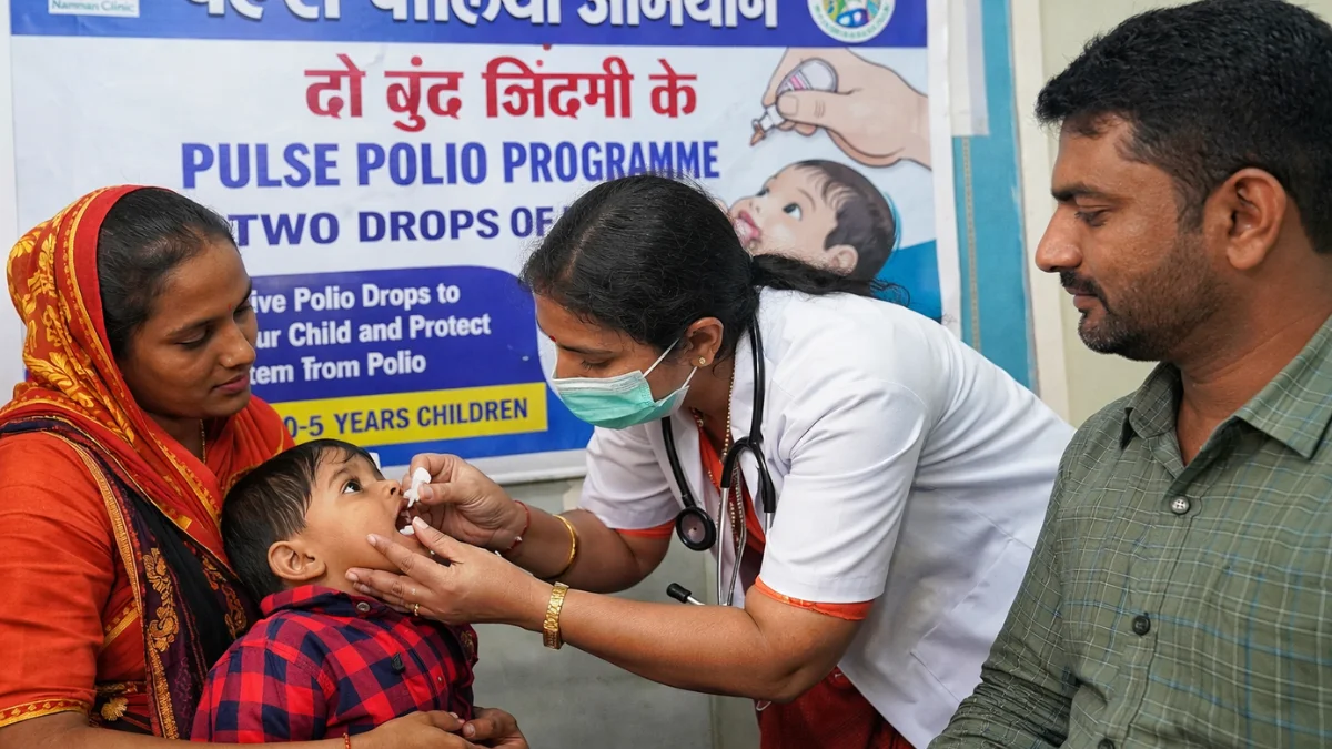 Pulse Polio programme in Hubballi where healthcare worker gives polio drops to a child